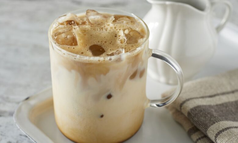 A glass of refreshing homemade iced coffee with milk and ice cubes
