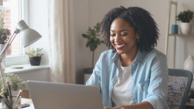 person working happily from a home office setup, with a laptop, notebook, and phone, symbolizing a successful home-based business.